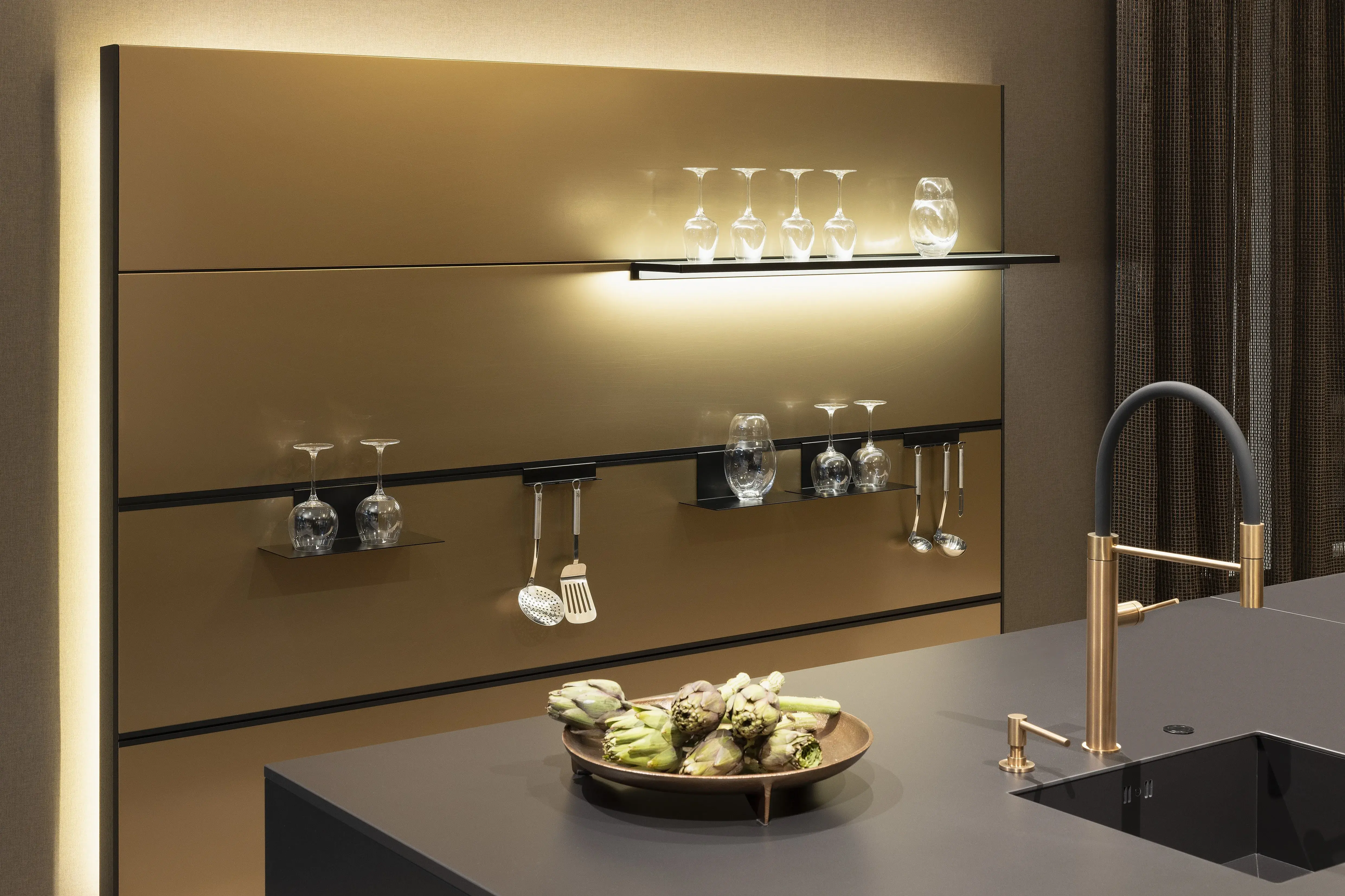 APL: Silk Negro Naturale (Keramik) 16 mm   Front: AV 6023-GL Eiche-schwarz Echtholzfurnier Rille AV 7070 Industriestahl Bronze, Metalliclack Korpus: 4059 Titan Griff: Kehlleiste 355 Schwarz matt Geräte: Miele Armatur: Gessi Features: Regalwandlösung mit beleuchtetem Wandboard, Oberfläche von Hand bearbeitet, Materialmix, Trendthema Bronze, Glasschublade mit Plexiglas in Schwarz getönt, Thekenlösung mittig, Wand aus Oberflächenmaterial in Bronze mit beleuchteten Funktionsleisten für Gläser, etc. 